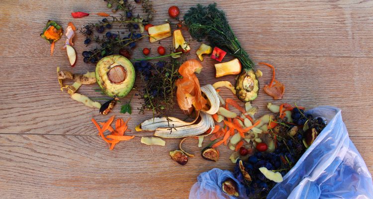 Domestic waste for compost from fruits and vegetables in the garbage bag on the table.